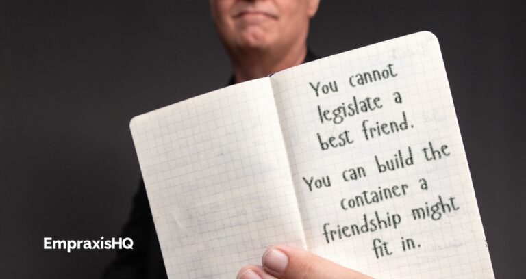 Tim Miles holding an open pocket notebook, on which is written "You cannot legislate a best friend. You can build the container a friendship might fit in."