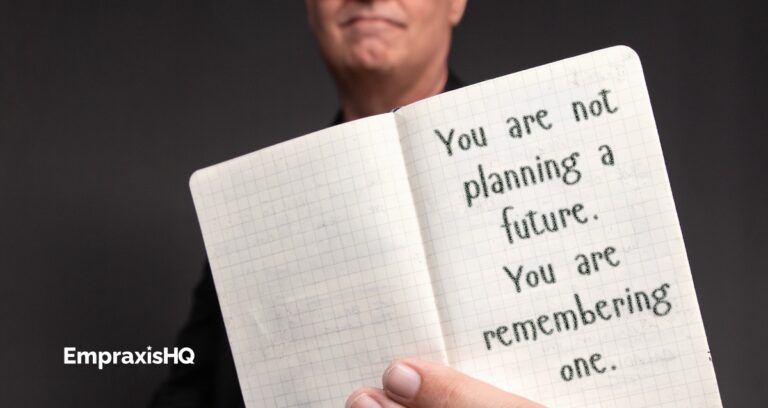Tim Miles holding an open pocket notebook, on which is written "You are not planning a future. You are remembering one."